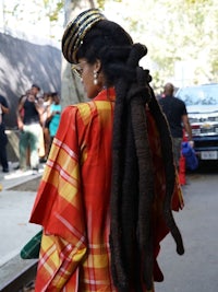 a woman with dreadlocks walking down the street