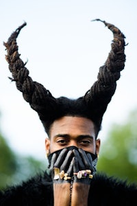 a man with horns covering his face